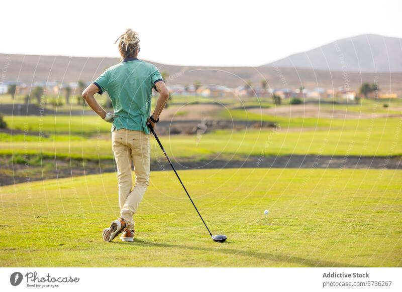 Golfer preparing for a shot on a sunny course golfer golfing golf course tee fairway golf club driver sports outdoor game leisure hobby green grass landscape