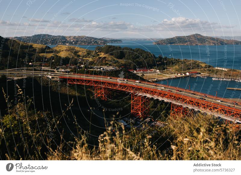 The Golden Gate Bridge stands out against the natural landscape of hills and waters of the San Francisco Bay, under the soft spring light bay bridge red