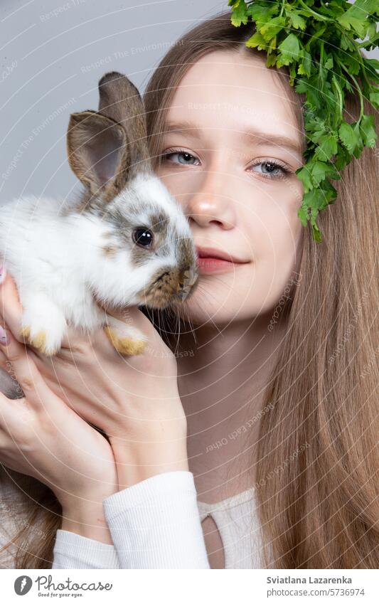 Portrait of a rural girl with a bunch of parsley on her head and a rabbit. Cute Animal pets Small Caucasian ethnicity Child portrait one person Close-up Girl