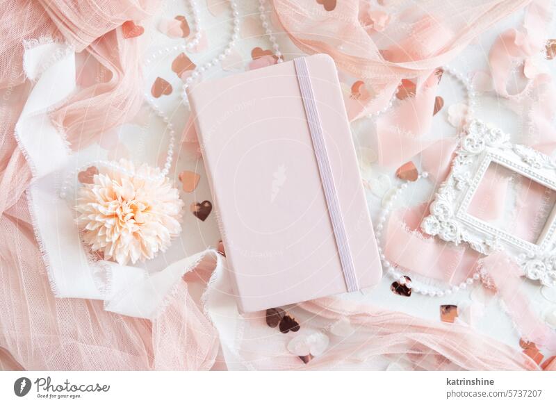 Pink hardcover notebook near hearts and romantic pink decor top view, textbook mockup valentines tulle spring mothers day WEDDING light pink pastel blank