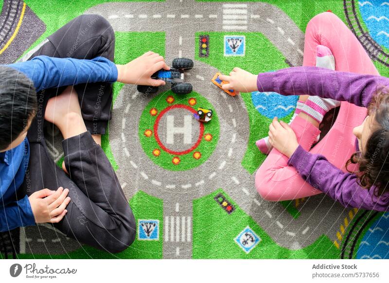 Children playing with toy cars on a colorful play mat children overhead view hands vibrant road-themed boy girl indoor leisure activity game playtime fabric