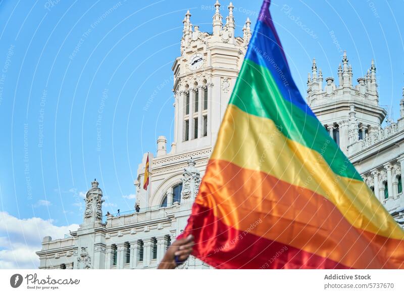 Rainbow flag waving in front of a classic building pride rainbow flag lgbtiq diversity equality rights celebration colorful architecture sky blue historical