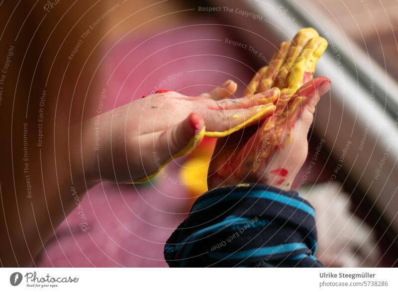 A child rubs yellow finger paint in his hands Painting (action, artwork) children kuns children's art Finger paint Yellow Hand Joy fun Window