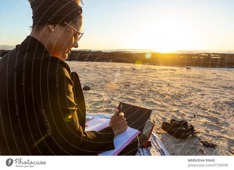 Working beachside during a stunning sunset digital nomad work mobile office tablet sand woman technology remote work freedom lifestyle travel job nature evening