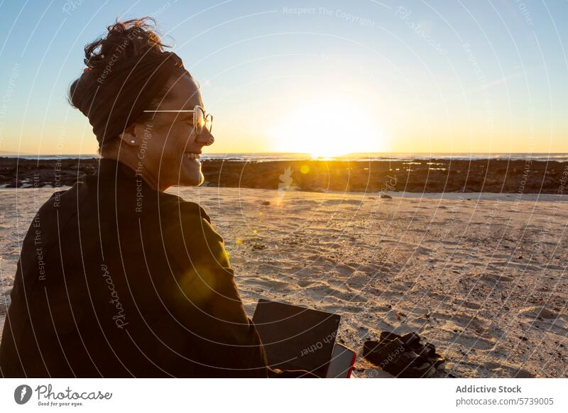 Smiling Digital Nomad Working at Beach During Sunset woman digital nomad beach sunset laptop work travel lifestyle outdoor remote job technology wireless