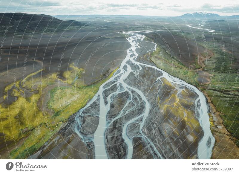 Aerial view of a braided river in Iceland's rugged landscape iceland aerial view volcanic terrain verdant nature natural pattern winding river riverbed