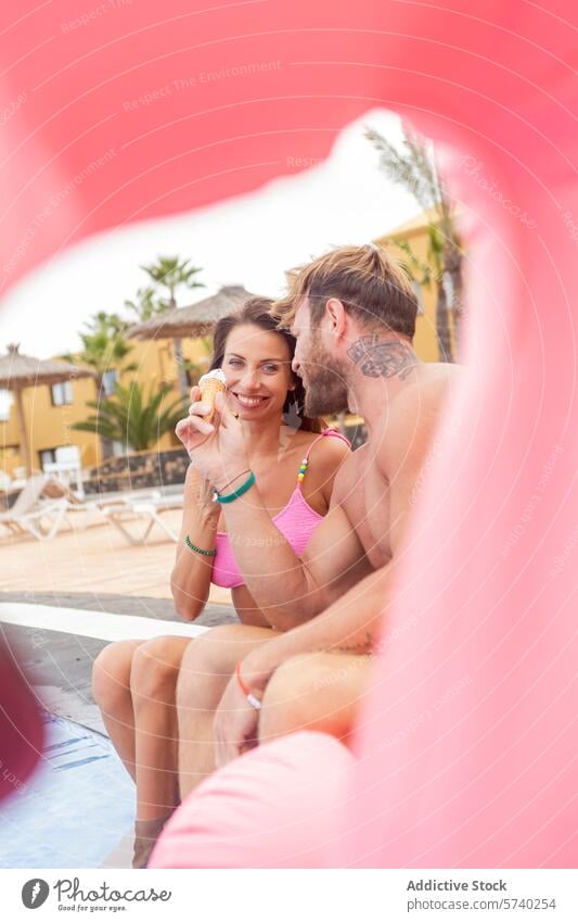 Playful poolside moment framed by a pink float couple playful sunny day swimwear relaxation vacation leisure fun summer joy happiness lifestyle woman tattoo