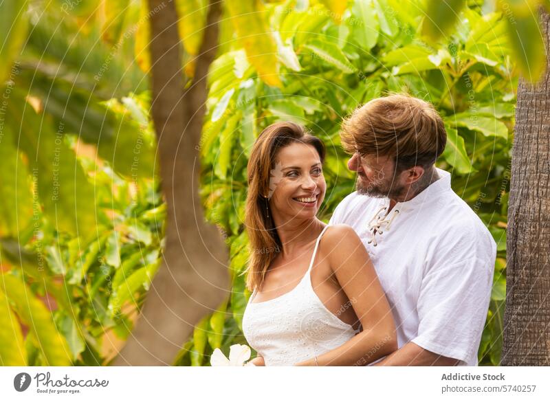Romantic couple embracing in tropical garden love embrace romance affection connection tenderness joy smiling relationship happiness nature outdoor bonding