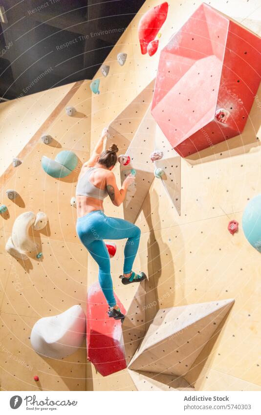 Indoor rock climbing adventure with a young woman indoor wall activity sport fitness determination focus exercise grip hold strength agility challenge athletic