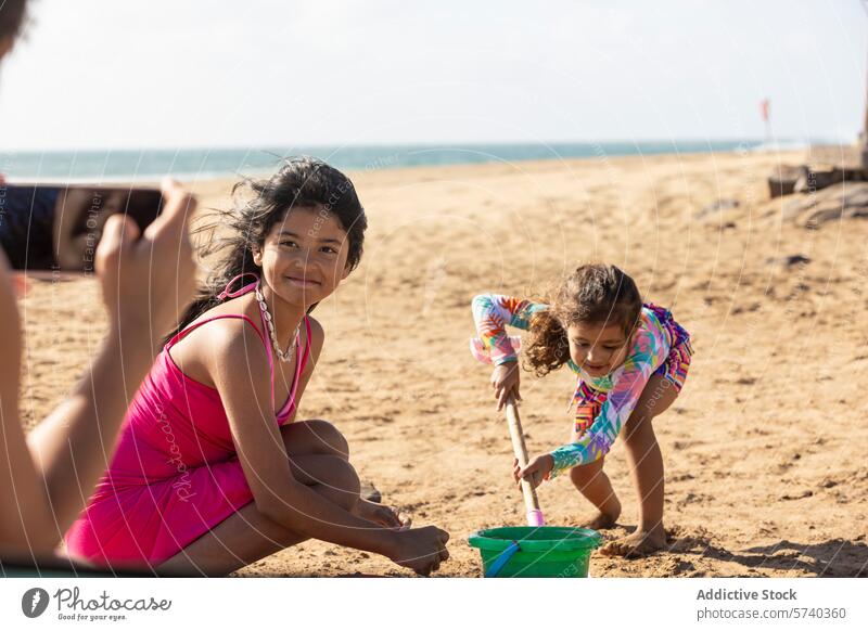 Anonymous single mother captures a precious moment as her daughters play with sand on a sunny beach, full of joy and laughter playtime single parent family