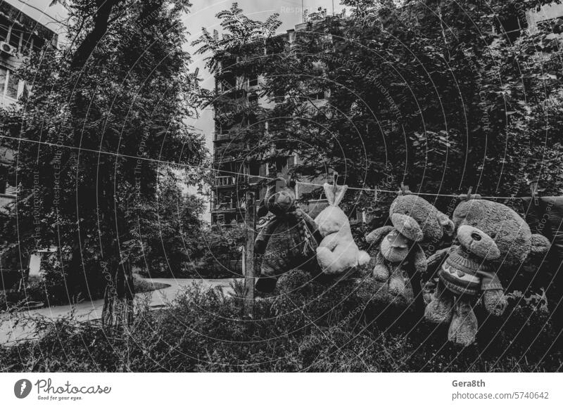 children's toys hang on a rope against the background of destroyed burnt houses in Ukraine Donetsk Kherson Kyiv Lugansk Mariupol Russia Zaporozhye abandon