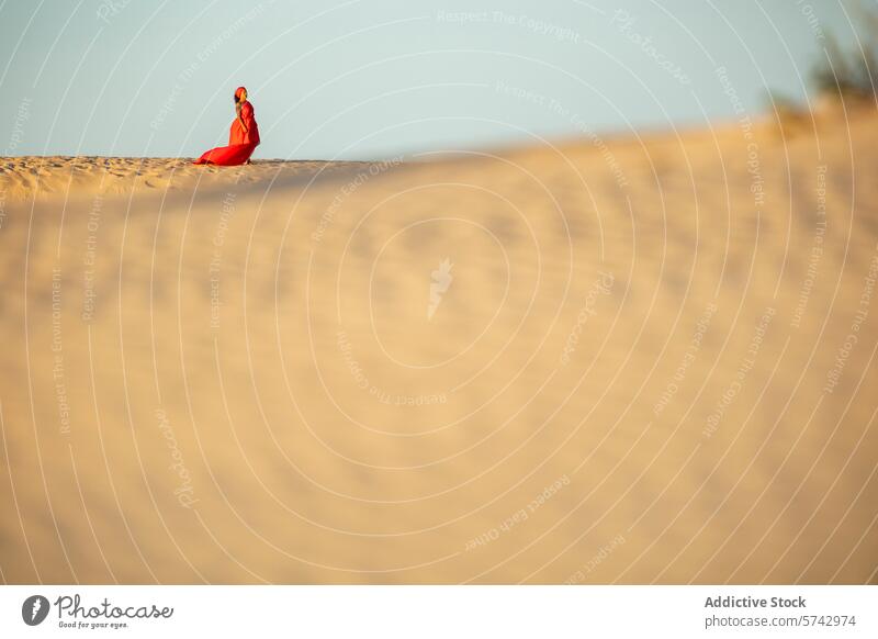 Elegant woman in red dress seated on a desert dune dunes sand sitting elegant solitude nature outdoors fashion landscape serenity calm travel remote tranquility