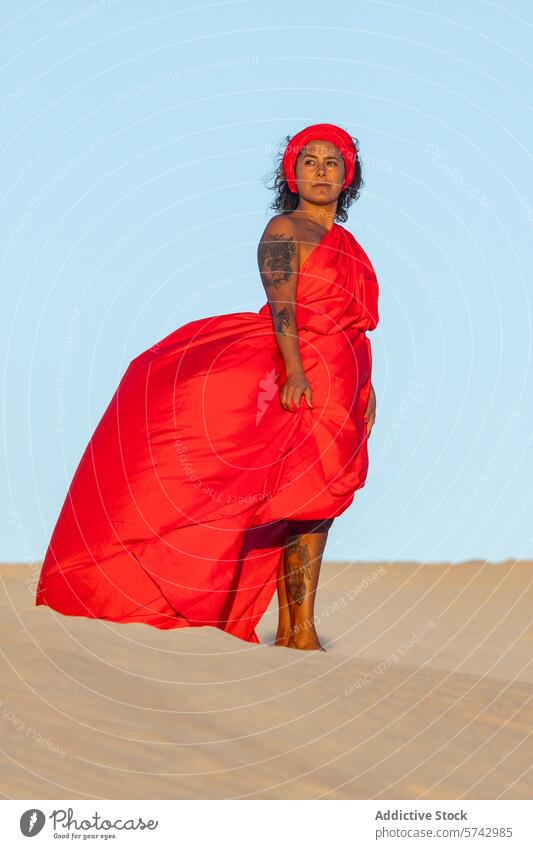 Elegant Woman in Vibrant Red Dress Poses on Desert Dunes woman red dress desert dunes sand elegant outdoor majestic flowing vibrant fashion style gaze