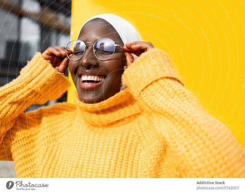 Smiling woman in colorful urban setting female black african american smiling yellow sweater glasses fashion vibrant background city casual streetwear portrait