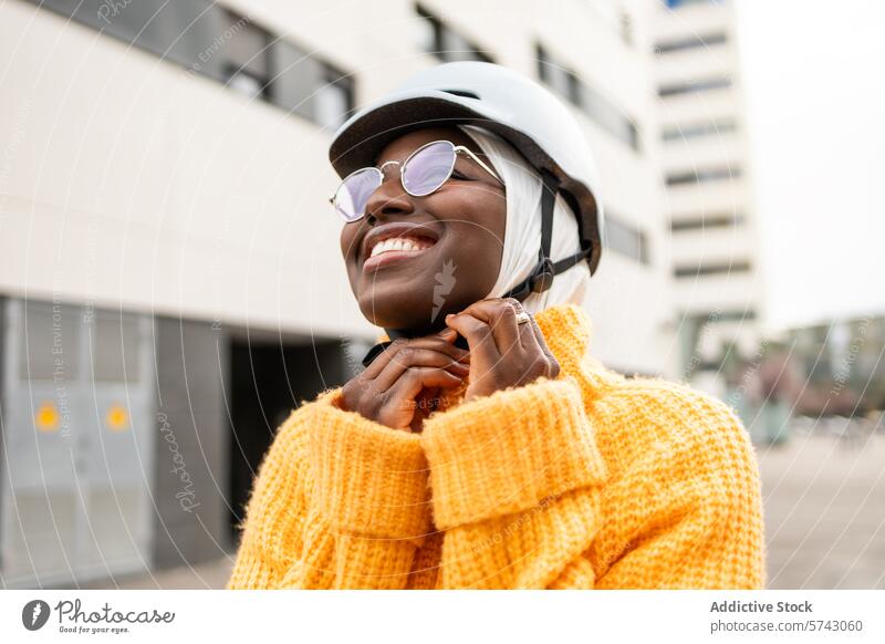 Joyful urban woman with bicycle helmet female black city happy smile outdoors happiness joy vibrant yellow sweater fashion streetwear modern lifestyle casual