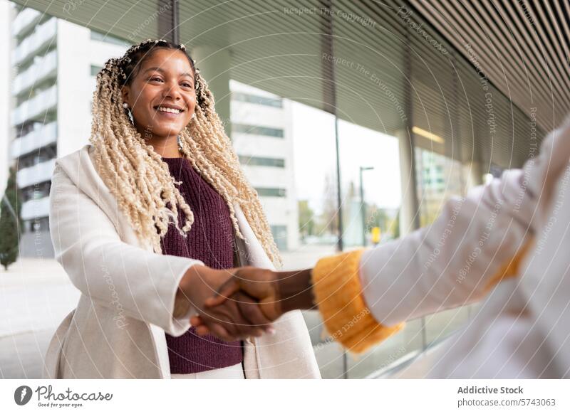 Smiling Black woman shaking hands in the city female black african american smiling handshake urban outdoor braided hair cheerful engaging business professional