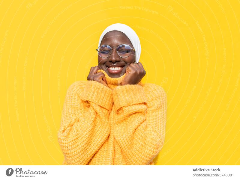 Cheerful African American woman in vibrant yellow female african american happiness joyful cheerful sweater hijab bright fashion style clothing comfort smiling