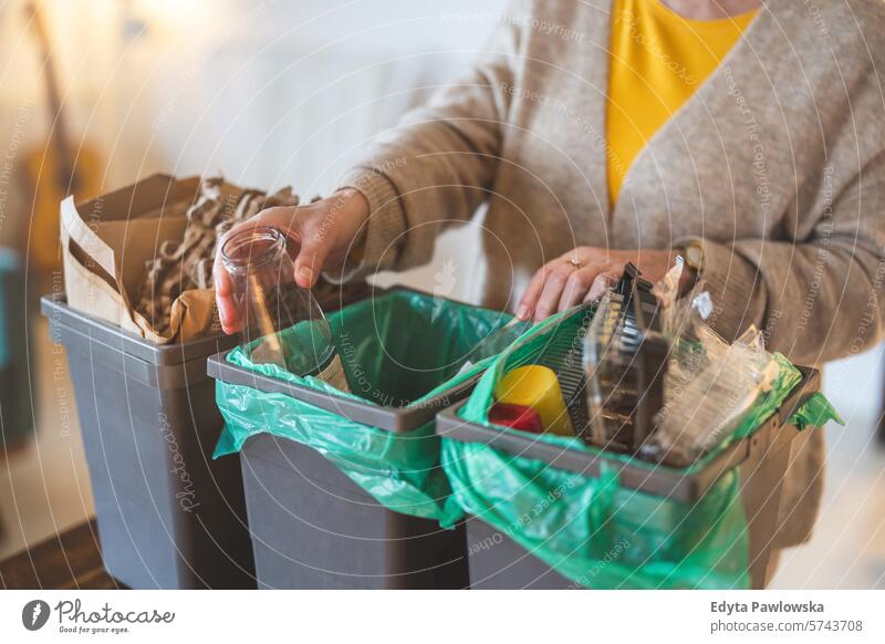 Senior woman sorting garbage in recycling bins at home people casual day portrait indoors real people white people adult mature retired old one person lifestyle