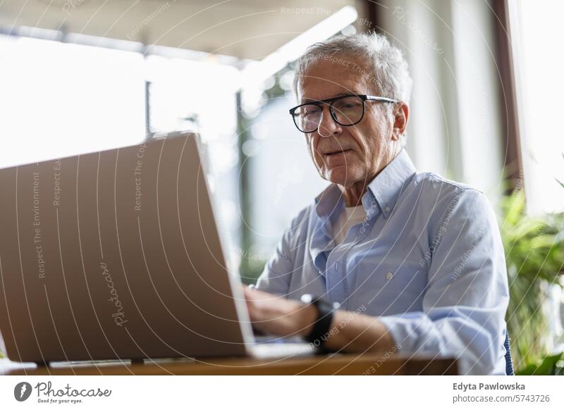 Senior man using laptop at home people caucasian grey hair casual day portrait indoors real people white people adult mature retired old one person lifestyle