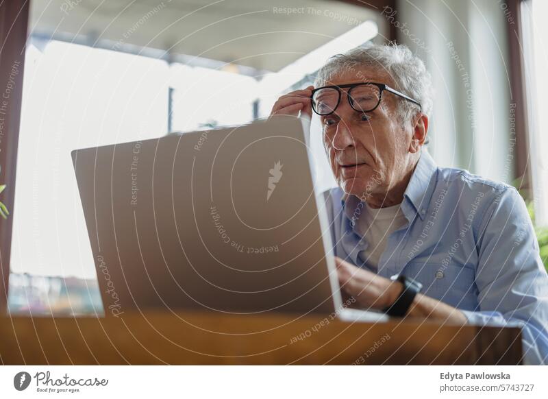 Senior man using laptop at home people caucasian grey hair casual day portrait indoors real people white people adult mature retired old one person lifestyle