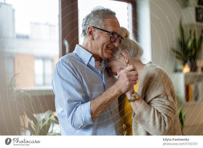Happy senior couple dancing in living room at home people caucasian grey hair casual day portrait indoors real people white people adult mature retired old