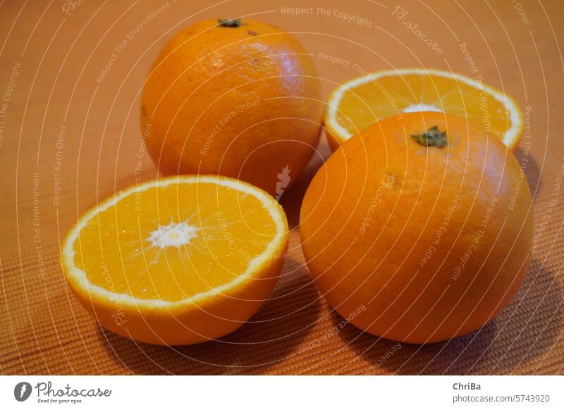 Oranges, partially halved on an orange tablecloth Juice Juicy orange Fresh Fruity Delicious Food Healthy Vitamin C Close-up Citrus fruits Healthy Eating