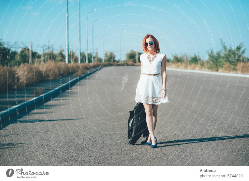 red-haired girl in a black jacket and blue glasses blue eyes bracelet dress happiness joy leather light portrait road rock summer walk white young