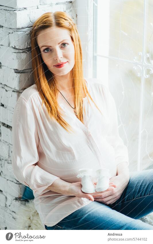 red-haired pregnant girl in a light blouse and blue jeans beautiful birth bright child day diversity family fpchallengediversity hairstyle inside love model