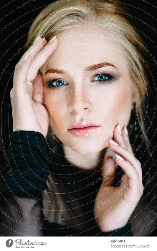 Blonde girl with blue eyes in a black dress Girl blonde turquoise interior portrait sit stand close-up view fashion evening lights warm glazy gentle young one