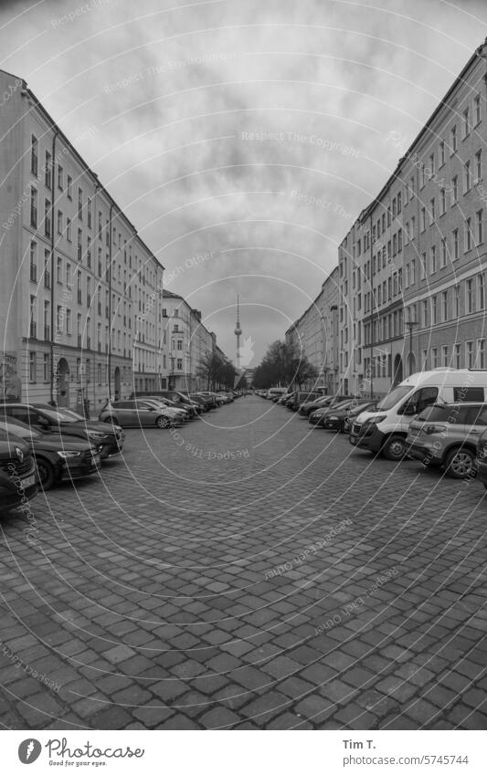 a cobblestone street with a view of the television tower Television tower Berlin b/w Cobblestones Day Town Capital city Downtown Exterior shot Architecture
