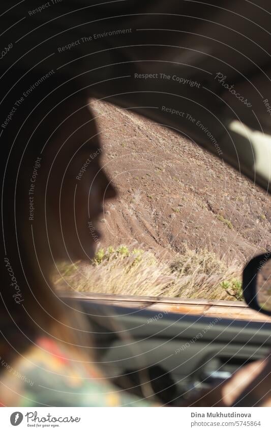 woman driving in a car  through mountains closeup, blurred with focus on the mountain. Road trip and adventure. driver female road trip travel journey young