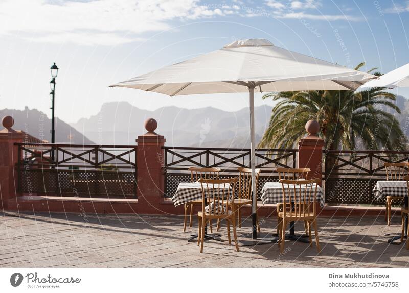 restaurant or cafe terrace with table and chairs and umbrella with a view on mountains Deserted Restaurant Terrace Café Gastronomy Sidewalk café Table Empty