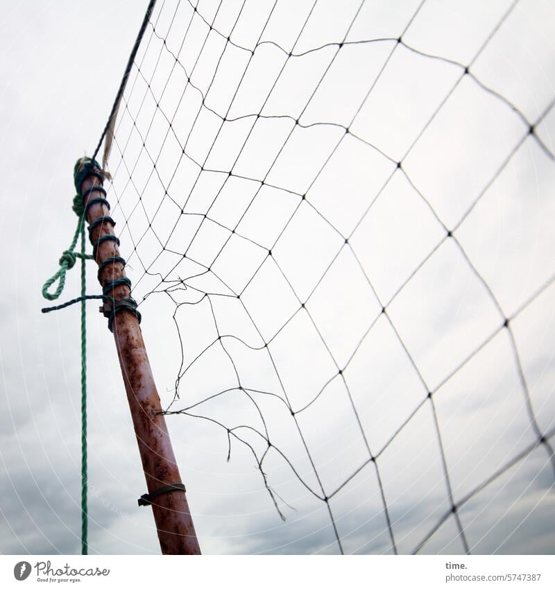 Torn volleyball net on a wooden pole in front of a cloudy sky Sky Weather Clouds Landscape Nature Perspective Volleyball net Net game device beach volleyball