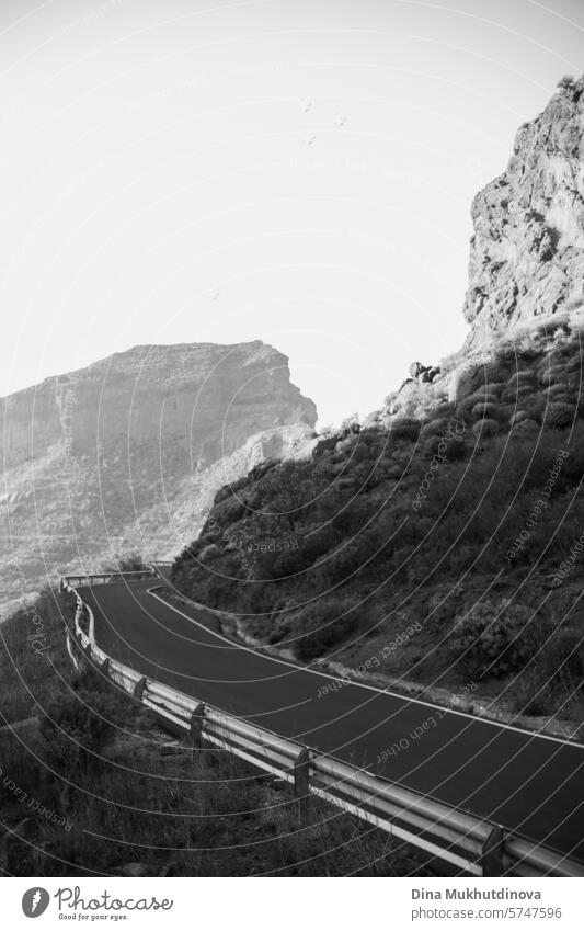 black and white photo of winding road in the mountains with a view over peaks of rocks and mountain in cloudy weather in Gran Canaria island gran canaria