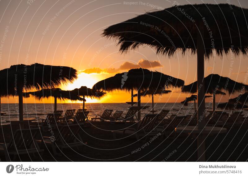 sunset on the beach with silhouettes of jute umbrellas and sun loungers. Travel and vacation, relax. sunrise landscape travel relaxing nature water sea summer