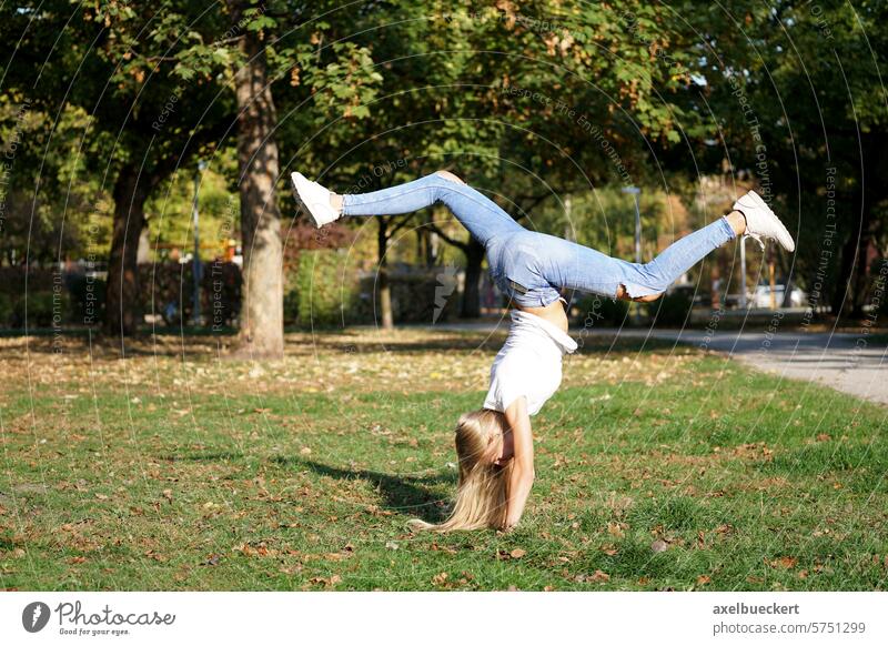 girl praticing handstand in a park nature woman lifestyle fun exercise outdoor activity carefree vitality gymnastics sport fitness young female spontaneity