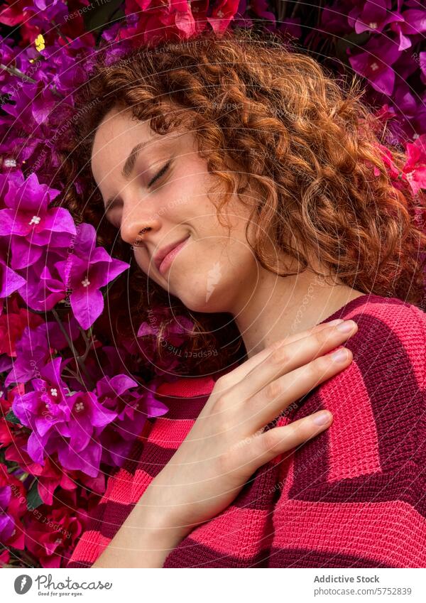 Serene redhead woman with closed eyes against colorful flowers curly hair peaceful serene pink flowers vibrant blossoms nature beauty relaxation tranquility
