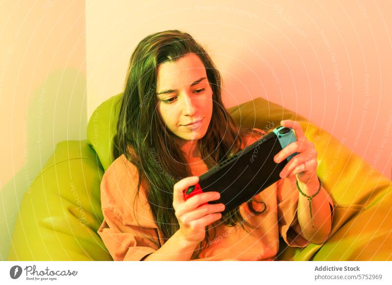 A relaxed gamer is captured in a moment of focus while playing on a portable gaming console, nestled in a cozy, brightly colored chair woman handheld leisure