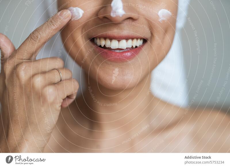 Woman applying facial cream with a joyful smile woman skincare beauty moisturizer application face close-up happiness healthcare routine grooming cosmetic