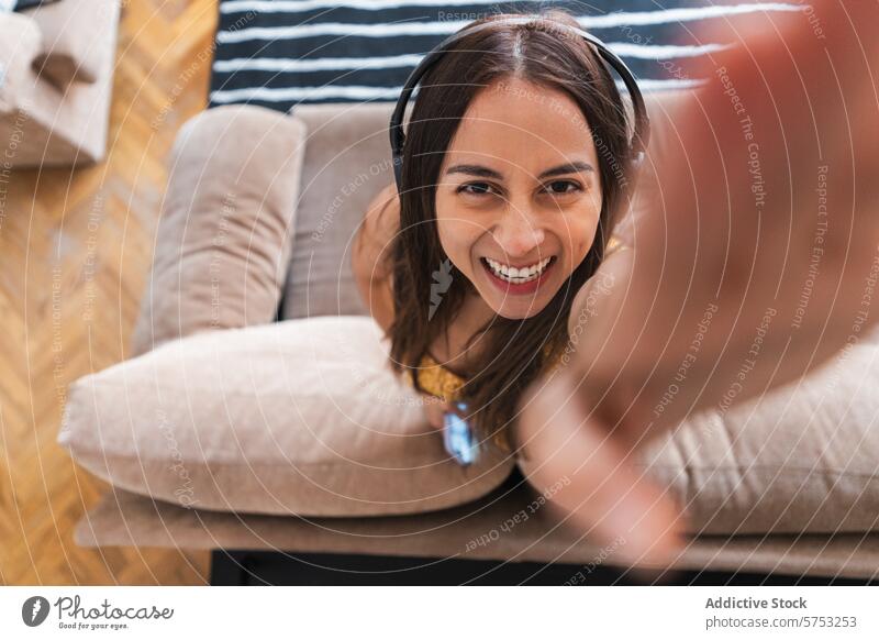 Happy young woman taking a selfie with headphones smiling camera happy cheerful personal moment photograph indoor leisure relaxation joy enjoyment music casual