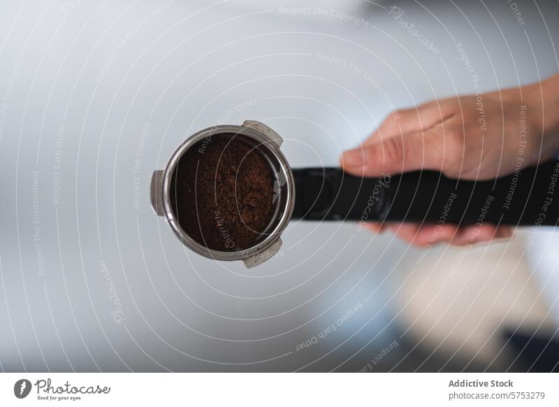 Preparing espresso with a portafilter and fresh coffee grounds brewing hand preparation barista caffeine beverage machine holder metal handle pressurized