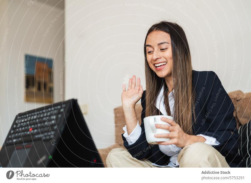 Young professional enjoying a coffee break during a video call woman young business attire mug conference home cheerful waving remote work virtual meeting