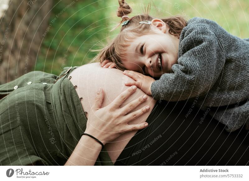 Little girl listening to pregnant belly in nature child pregnancy maternity bonding smile family outdoor affection young sibling unborn mother maternal love