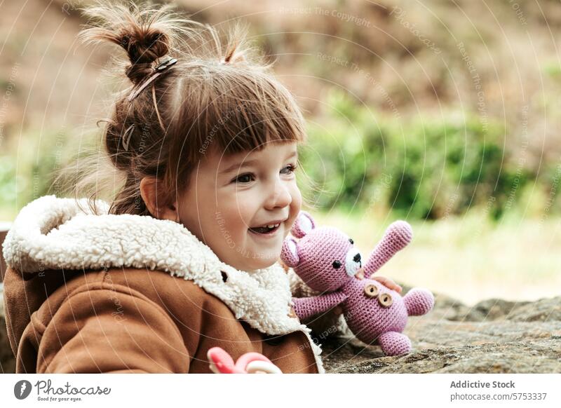 Laughing child with a plush toy outdoor girl happy laughing purple bunny nature joy playful innocence childhood smile adorable kid cheerfulness toddler young