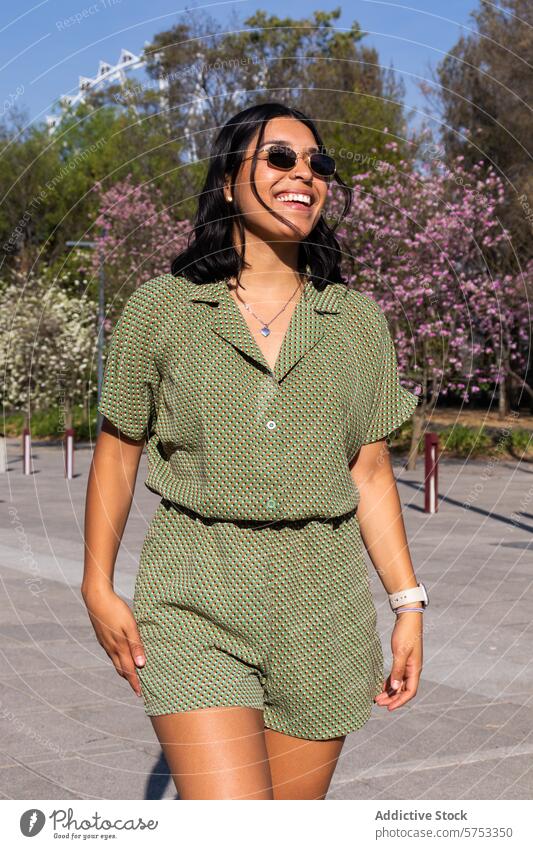 Smiling woman enjoying a sunny day outdoors in spring smile park blossom tree warm weather green outfit sunglasses cheerful stylish fashion nature bloom