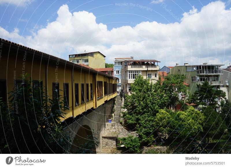 The historic Irgandi Bridge with stores and bazaars in summer against a blue sky with white clouds in sunshine in Bursa in the Uludag Mountains in Turkey