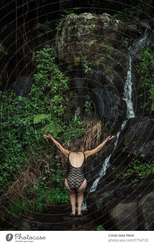 These wild and green jungles with a picturesque spring beneath some heavy rocks are a perfect lure for a gorgeous blonde girl in a swimsuit. She’s doing some kind of worshiping while being all pretty in the wilderness.