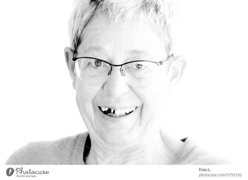Bite into a croquantei - happy Easter! Woman portrait Face Old gray hair Drooping eyelids crease Eyeglasses Tooth space makeshift Dental treatment