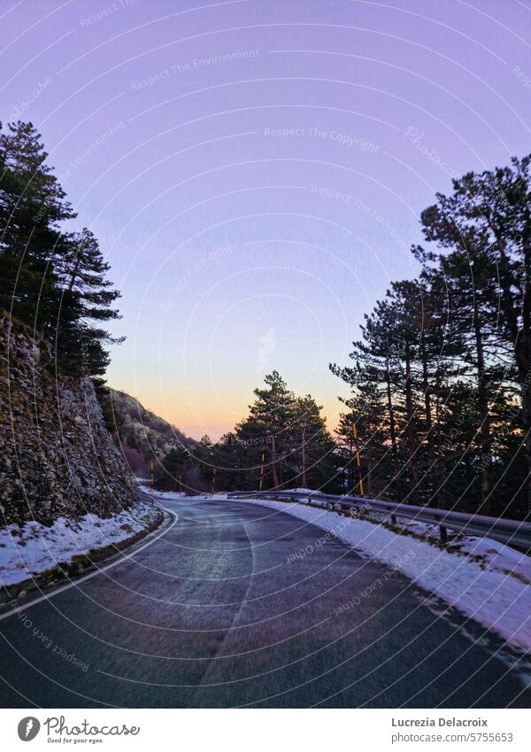 snow road in the mountains at sundown snowy suggestive Colour photo Symmetry street car Trees cold ice Sky sunset