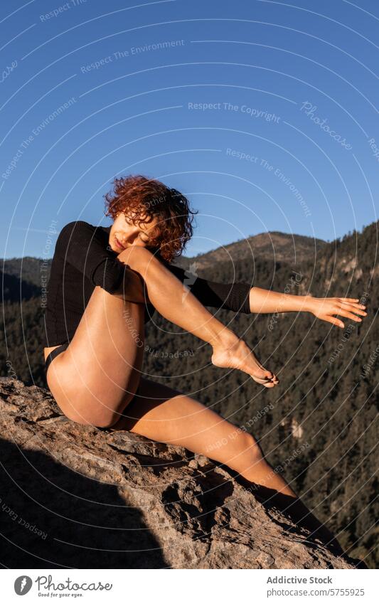 Graceful dancer posing on a rocky mountain at sunset contemporary pose elegance blue sky performer artistic flexibility grace nature outdoor woman serene rocks